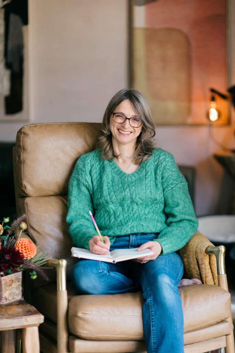 Cotswold Floral Workshop Teacher Sally Sola from Cheltenham Flower School smiles at the camera in a green jumper